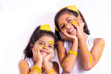 Two little girl, with her face painted to celebrate the yellow dayの写真素材