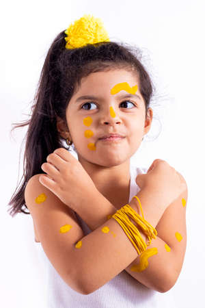 Happy little girl, with her face painted to celebrate the yellow dayの写真素材
