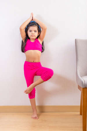 Cute little girl doing yoga at homeの写真素材