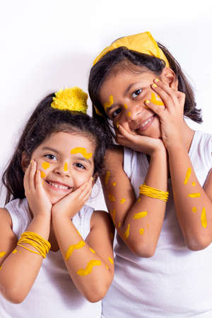 Two little girl, with her face painted to celebrate the yellow dayの写真素材