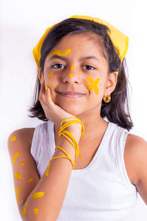 Happy little girl, with her face painted to celebrate the yellow dayの写真素材