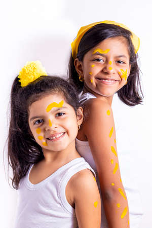 Two little girl, with her face painted to celebrate the yellow dayの写真素材
