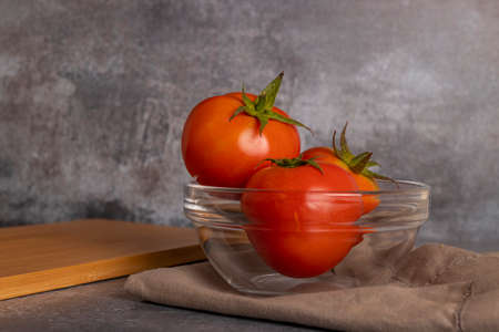 Tomatoes in salad inside a white bowl on grayish backgroundの写真素材