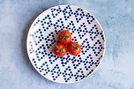 Cherry tomatoes on blue dotted plateの写真素材