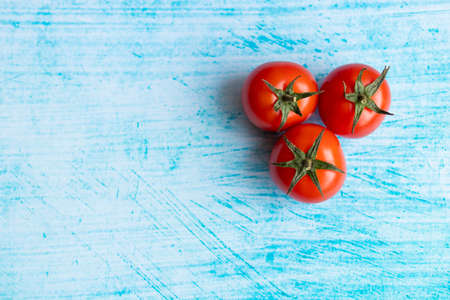Cherry tomatoes on blue brushstroke backgroundの写真素材