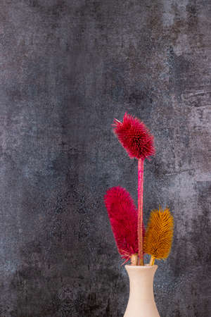 Dried colorful flowers placed in vase with gray backgroundの写真素材