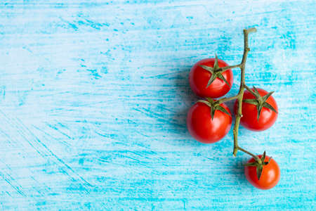 Cherry tomatoes on blue brushstroke backgroundの写真素材