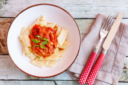 Short pasta dish with tomato sauce and basilの写真素材