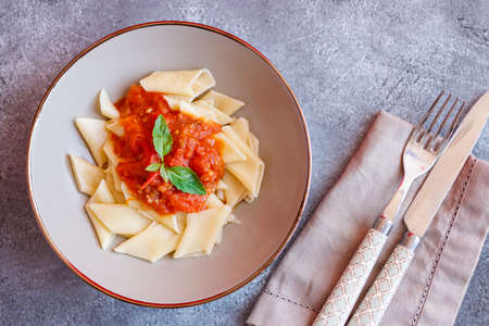 Short pasta dish with tomato sauce and basilの写真素材
