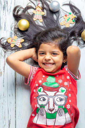 Cute little girl is playing with Santa's cookies and milk at Christmasの写真素材