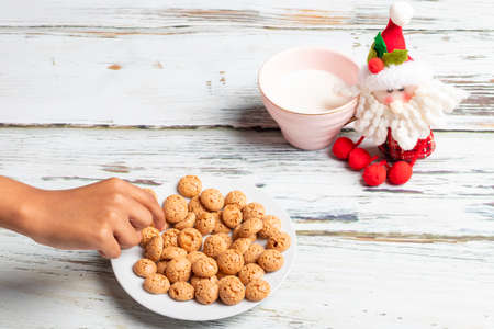 Cute little girl is playing with Santa's cookies and milk at Christmasの写真素材