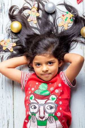 Cute little girl is playing with Santa's cookies and milk at Christmasの写真素材