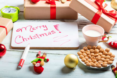 Cute little girl is playing with Santa's cookies and milk at Christmasの写真素材
