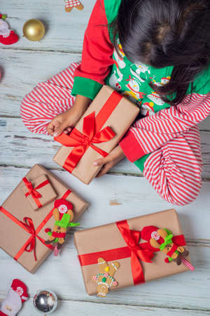Cute little girl is playing with Santa's cookies and milk at Christmasの写真素材