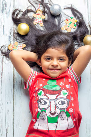 Cute little girl is playing with Santa's cookies and milk at Christmasの写真素材