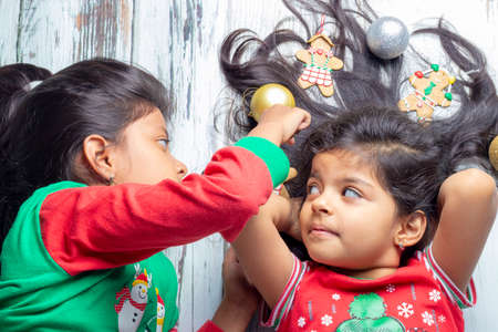 Cute little girl is playing with Santa's cookies and milk at Christmasの写真素材
