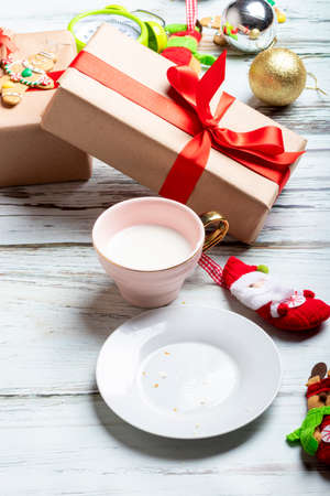 Cute little girl is playing with Santa's cookies and milk at Christmasの写真素材