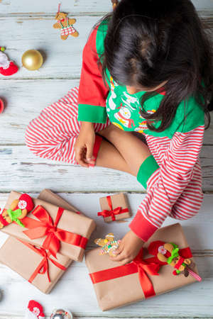 Cute little girl is playing with Santa's cookies and milk at Christmasの写真素材