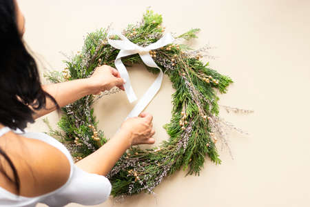 Cute woman decorates advent wreath with her handsの写真素材