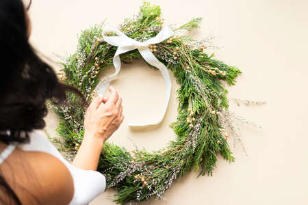 Cute woman decorates advent wreath with her handsの写真素材