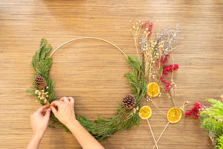 Cute woman decorates advent wreath with her handsの写真素材