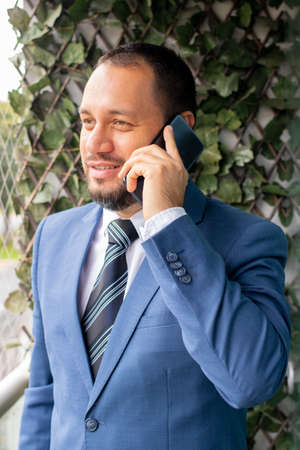Handsome man in a suit and tie, is talking on the phone