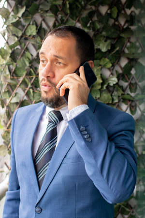 Handsome man in a suit and tie, is talking on the phoneの写真素材