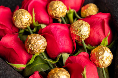 Bouquet of red roses with golden chocolatesの写真素材
