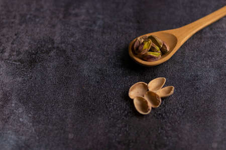 Raw organic pistachio nuts laid out on wooden spoonの写真素材