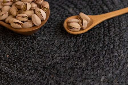 Raw organic pistachio nuts laid out on wooden spoonの写真素材