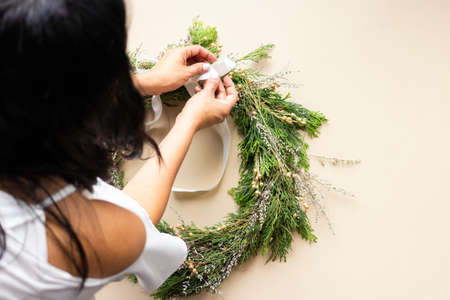 Cute woman decorates advent wreath with her handsの写真素材