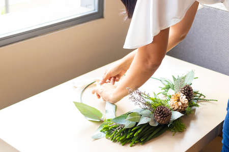 Cute woman decorates advent wreath with her handsの写真素材