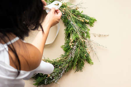 Cute woman decorates advent wreath with her handsの写真素材