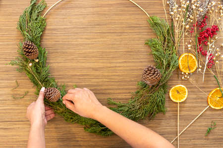 Cute woman decorates advent wreath with her handsの写真素材