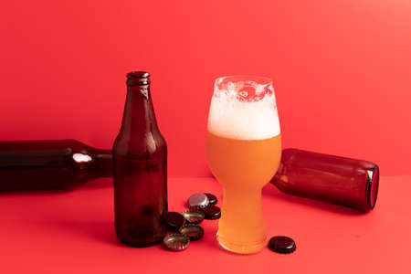 IPA beer glass and various bottles with red backgroundの写真素材