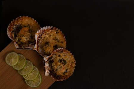 Grilled Parmesan Scallops served on a table with lemonの写真素材