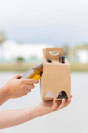 Holding 4 pack of beers to celebrate on the beachの写真素材