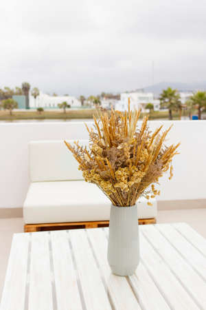 Cute bouquet of dried flowers (Bunny tail) on the terrace of a houseの写真素材