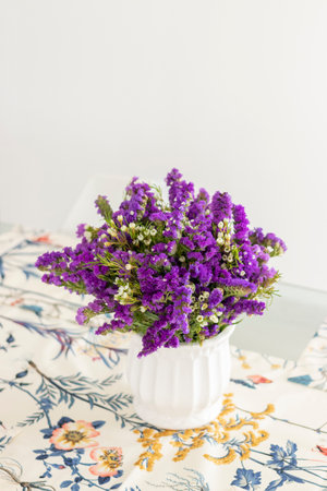 Cute flower arrangement with purple statice, decorating the dinner tableの写真素材