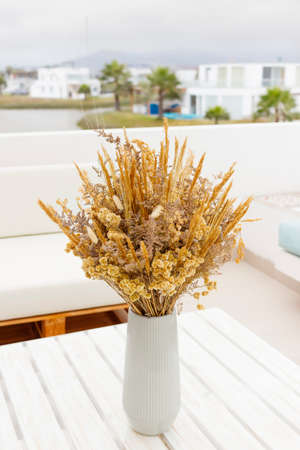 Cute bouquet of dried flowers (Bunny tail) on the terrace of a houseの写真素材