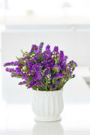 Nice flower arrangement with purple statice, decorating the spaces of a beautiful kitchenの写真素材