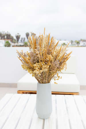 Cute bouquet of dried flowers (Bunny tail) on the terrace of a houseの写真素材