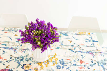 Cute flower arrangement with purple statice, decorating the dinner tableの写真素材