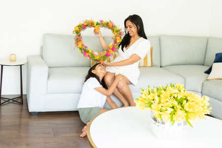 Beautiful daughter gives a heart-shaped flower arrangement to her momの写真素材