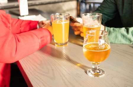 Friends celebrating with beers in a pubの写真素材