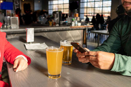 Friends celebrating with beers in a pubの写真素材