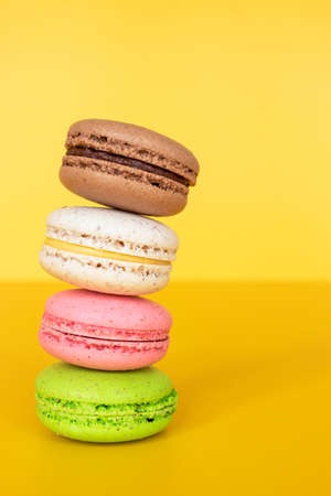 Various colorful macaroons on yellow backgroundの写真素材