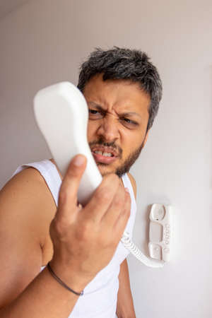 Puzzled man answering the phoneの写真素材