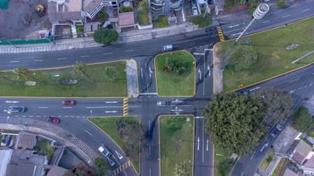 Aerial view of an intersection with vehicles and zebra lines