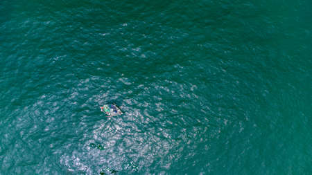 Lonely boat with two fishermen in the green colored sea